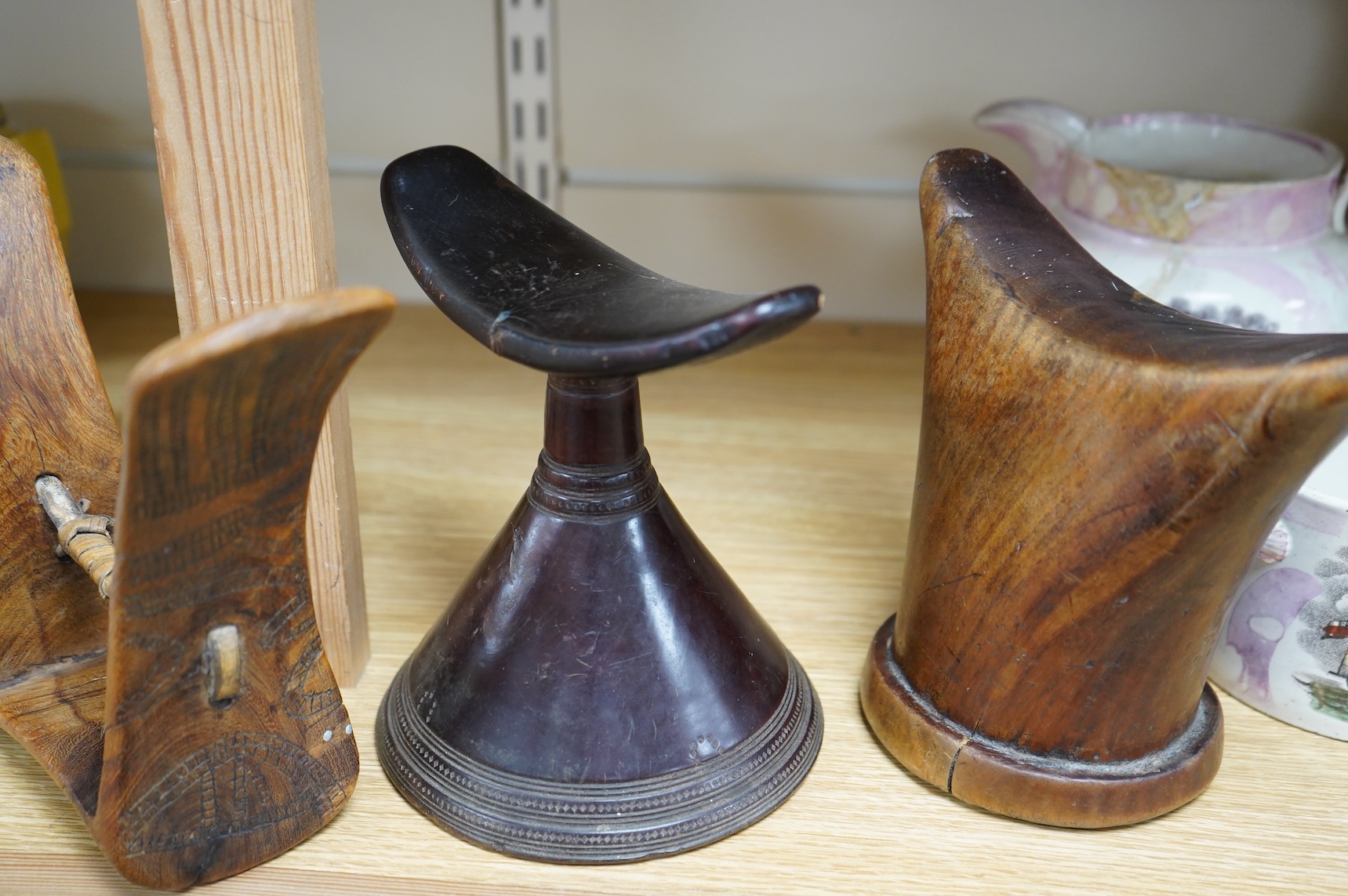Three African wood head rests, two with carved decoration, largest 18cm high